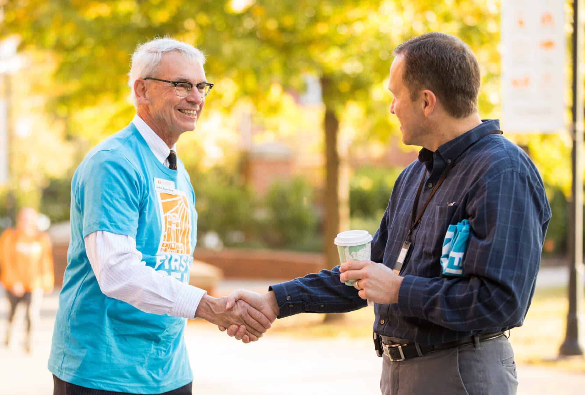 Provost John Zomchick shakes hand with student