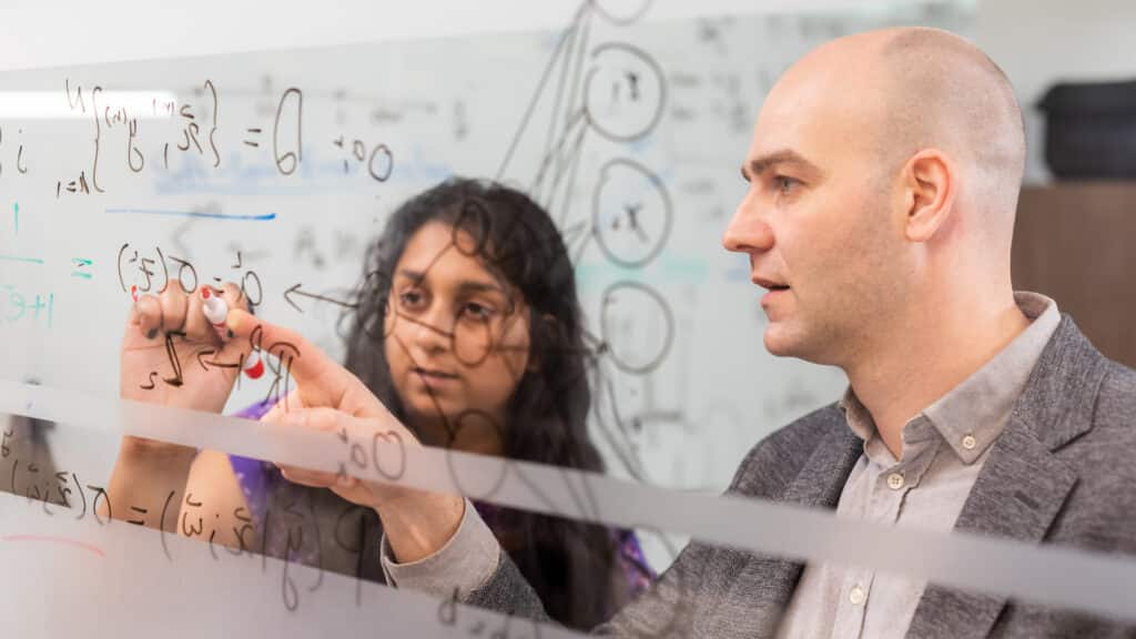 Adrian Del Maestro discusses formulas with a student on his office window int he IAMM building on April 01, 2022. Photo by Steven Bridges/University of Tennessee