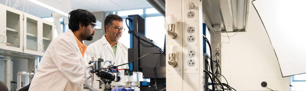 Senior Research Associate Gabriel A. Goenaga-Jiménez works with graduate student at the scanning electrochemical workstation in a lab in Zeanah Engineering Complex