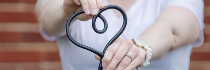 Nurse holding stethoscope in the shape of a heart